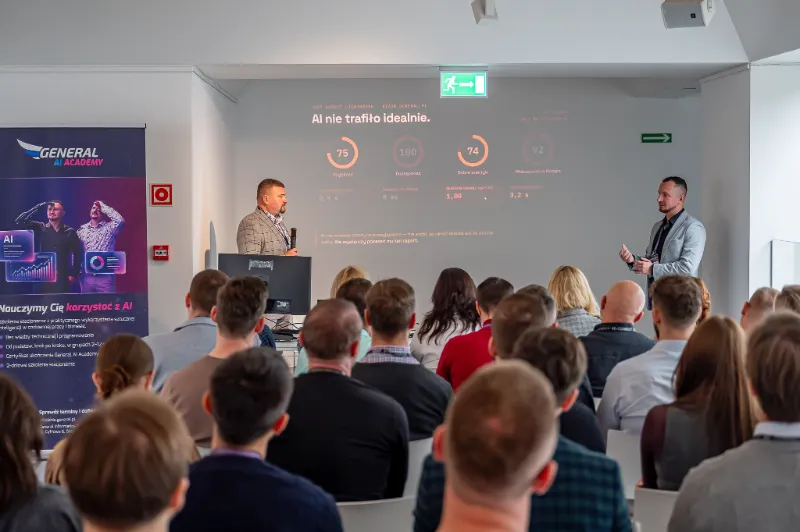 Michał Olejarski przy pulpicie i Radosław Zacha przed ekranem z wynikami testu Google Lighthouse strony aizor.general.pl: szybkość 75, dostępność 100, dobre praktyki 74, widoczność w Google 92; nagłówek „AI nie trafiło idealnie.”